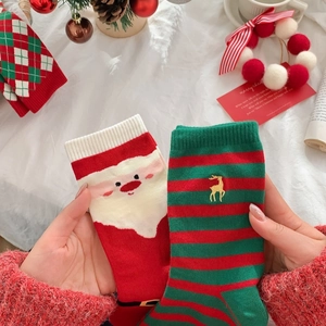 Detail of red Christmas crew socks featuring Santa Claus patterns and festive embroidery