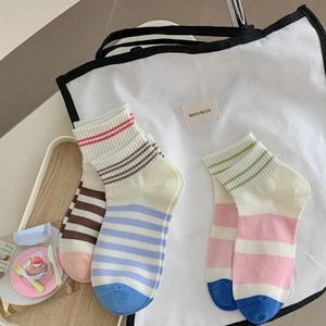 Striped combed cotton low-cut student socks in various colors on a canvas bag