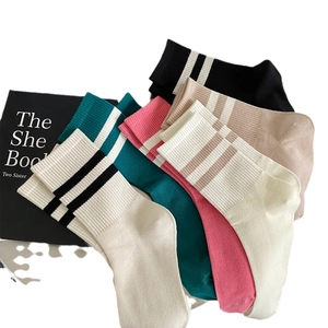 Five pairs of striped mid-calf cotton sports socks in assorted colors on flat lay