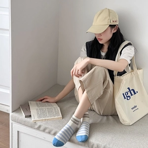 Close-up of blue and white striped cotton socks with reinforced toe on a model