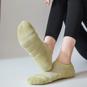 Nahaufnahme der dicken Frotteesohle und des Mesh-Gewebes bei grünen Sportsocken