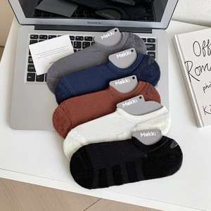 Detail of five-color thick cotton invisible socks with reinforced heel on laptop
