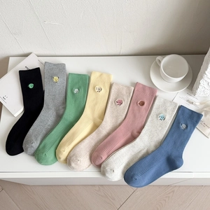 Detail view of eight colorful ribbed cotton socks with cute emoji face embroidery
