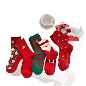 Five pairs of festive Christmas cotton socks in red and green with holiday patterns
