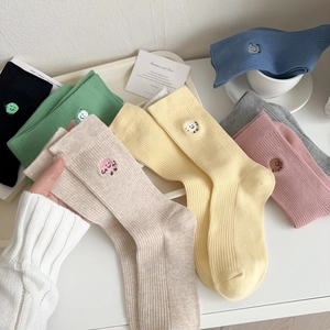 Detail of colorful ribbed cotton socks with cute cartoon embroidery icons