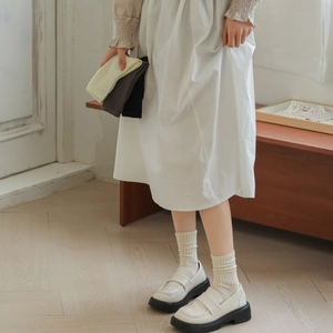 Close-up of ribbed cotton crew socks in cream, grey, and black colors for women