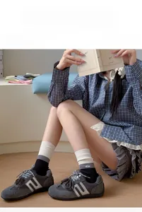 Detail of color-block ribbed cotton socks with letter embroidery styled with sneakers