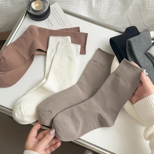 Set minimalistischer Baumwollsocken in neutralen Tönen auf einem weißen Tablett