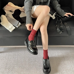 Nahaufnahme roter Baumwoll-Stricksocken mit Rippenmuster und verschiedenen Farbvarianten