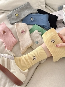 Close-up of ribbed cotton crew socks with cute cartoon embroidery in diverse colors