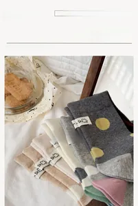 Dettaglio di calze in maglia con etichette a tema cielo e motivi a grandi pois