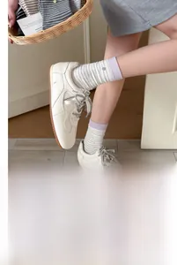 Detail of grey striped cotton socks with purple rib cuff and decorative mini label