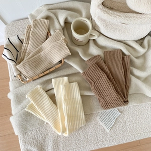 Scaldamuscoli spessi a maglia color crema, beige e marrone con bordi arricciati e costine