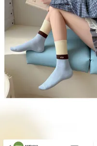 Detail of tricolor ribbed cotton crew socks with allo embroidery on blue background