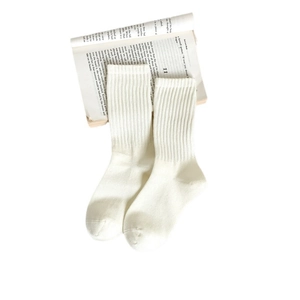 White ribbed cotton crew socks for women displayed on an open book for a minimalist style