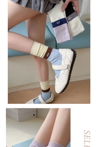 Close-up of tricolor patchwork knitted cotton socks with allo letter embroidery