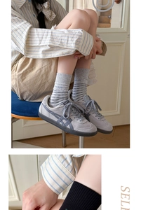Détail de chaussettes grises rayées portées avec des baskets vintage en daim au style décontracté