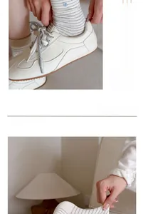 Détail de chaussettes en coton rayées avec broderie cœur bleu et baskets blanches