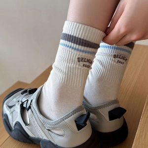 White ribbed mid-calf cotton socks featuring blue stripes and embroidered side lettering
