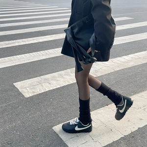 Dettaglio borsa in pelle nera con manico a nodo e logo dorato in stile elegante