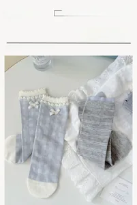 Gros plan sur des chaussettes en coton bleu à damier avec dentelle et petit ruban