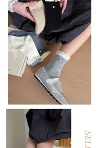 Detail of knit socks with elegant pearl embellishment and soft ribbed texture