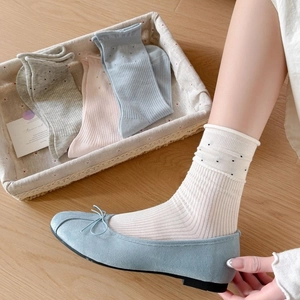 Witte polkadot sokken met blauwe ballerina's in een gezellige minimalistische setting