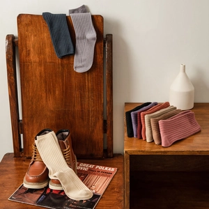 Retro multi-color ribbed cotton mid-tube socks displayed on vintage wooden furniture