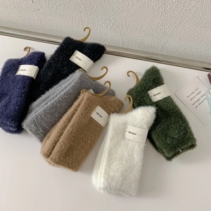 Detailed texture of thick mink velvet socks in various colors with luxury paper packaging