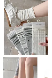 Details von grau-weißen Damen-Stricksocken mit vertikalen Texturen und Rippbündchen