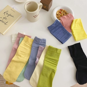 Detailed flat lay of colorful mid-calf cotton socks in vibrant candy colors on a desk