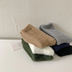 Detailed close-up of thick winter coral fleece socks in various warm solid colors