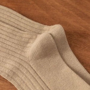 Close-up of khaki ribbed cotton socks showing the detailed knit texture and heel seam