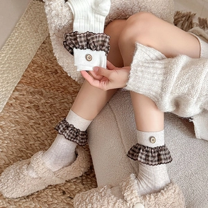 Detail of vintage knit socks with plaid ruffle trim and decorative side buttons