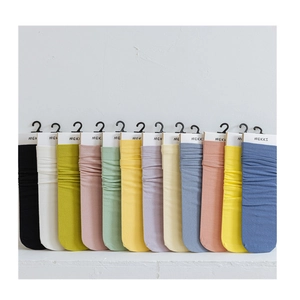 Set of 12 solid color velvet crew socks in various pastel shades with minimalist packaging