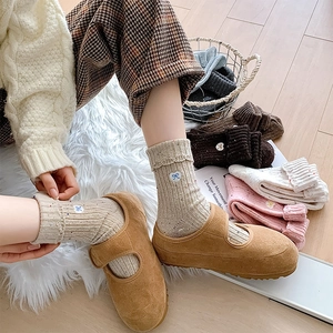 Detail of wool socks with heart bow embroidery and brown suede Mary Jane shoes