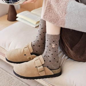 Close-up of cozy wool socks with polka dots and cute alpaca embroidery for winter