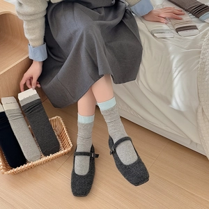 Detailed close-up of ribbed crew socks with contrast blue cuff, styled with Mary Jane shoes