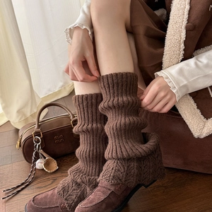 Détail de jambières en tricot épais marron café avec des motifs de torsades vintage