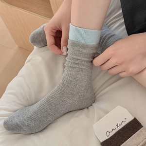 Detail of grey crew socks with light blue ribbed cuff trim in a soft knit texture