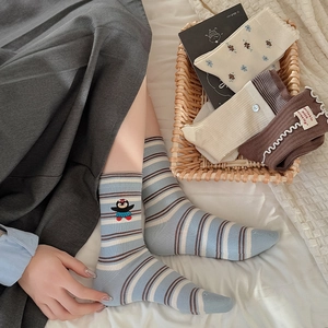 Details von Baumwollsocken mit Pinguin-Stickerei, Blumenmustern und Wellenkanten