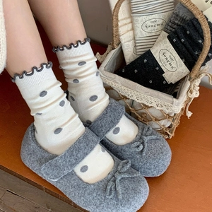 Detail of warm wool blend polka dot socks with ruffled edges and felt Mary Jane shoes