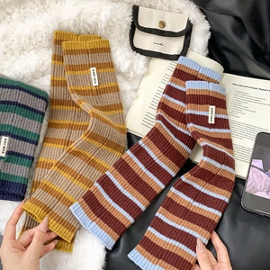 Close-up of colorful striped knit leg warmers with vertical ribbing and brand label