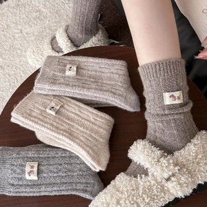 Detailed close-up of thick knit wool socks featuring cute dog labels and ribbed texture