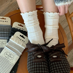 Detail of wool knit mid-tube socks featuring frilly cuffs and vertical ribbed texture