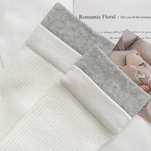 Close-up of ribbed knit cotton socks in white and grey with soft textured fabric