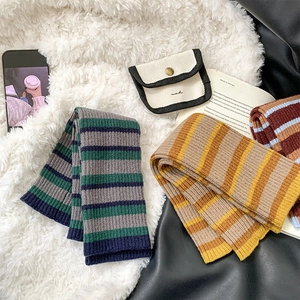 Detail of colorful striped knit leg warmers with fine texture and a matching canvas pouch