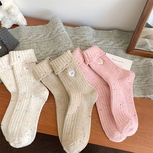 Detail of wool socks with heart bow embroidery and colorful dot yarn texture