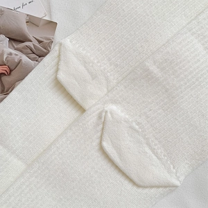 Macro detail of white crew socks showing vertical ribbed knit texture and soft cotton fabric