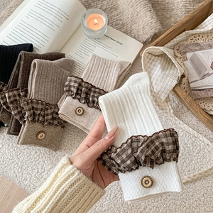 Detail of vintage plaid ruffle cuffs and button accents on ribbed mid-calf socks